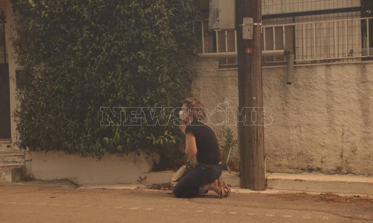 Συγκλονιστική εικόνα: Γυναίκα προσεύχεται βλέποντας τις φλόγες να πλησιάζουν το σπίτι της